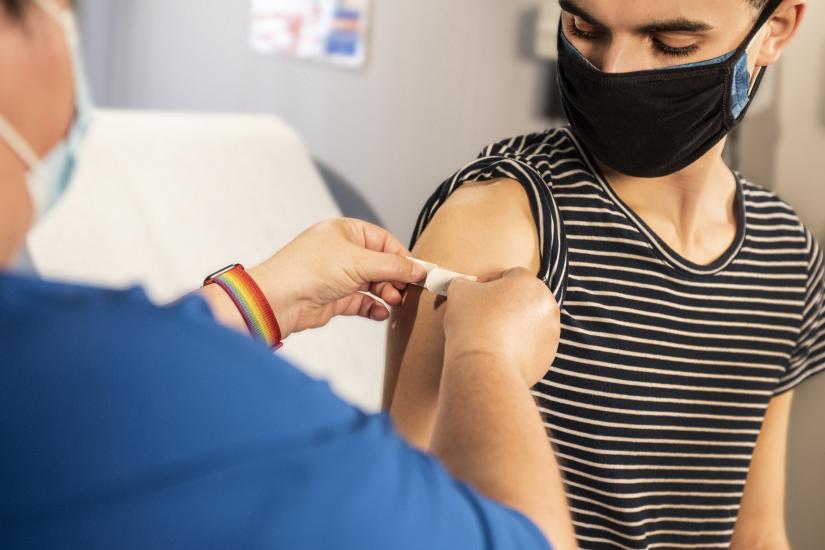 Healthcare worker applies a bandaid to a person after a vaccination