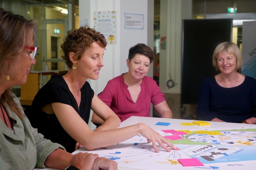 Smiling colleagues working together around table with coloured post-it notes
