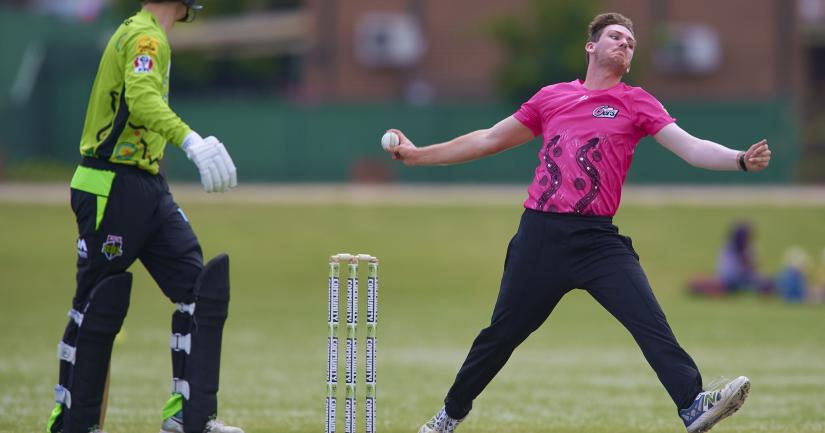 Action photo of Nicholas Hay taken mid-bowl during a cricket match 