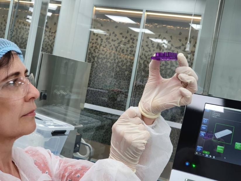 A Perkin Elmer scientist demonstrates how to handle a purple microfluidic chip