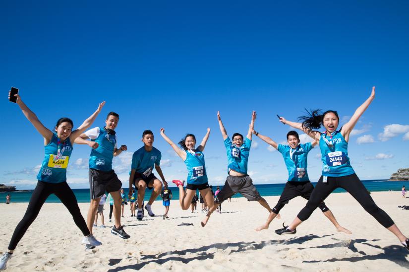 Team of students jump at the beach