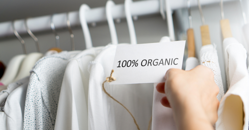 Clothes on hangers with a label that reads '100% organic'