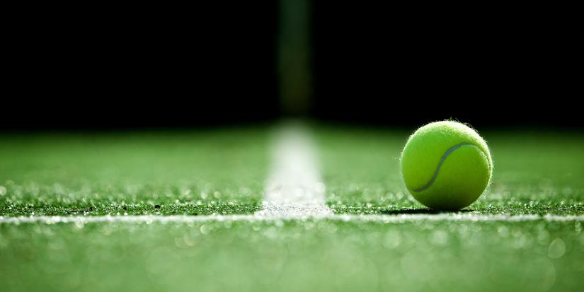 A tennis ball on a lawn tennis court