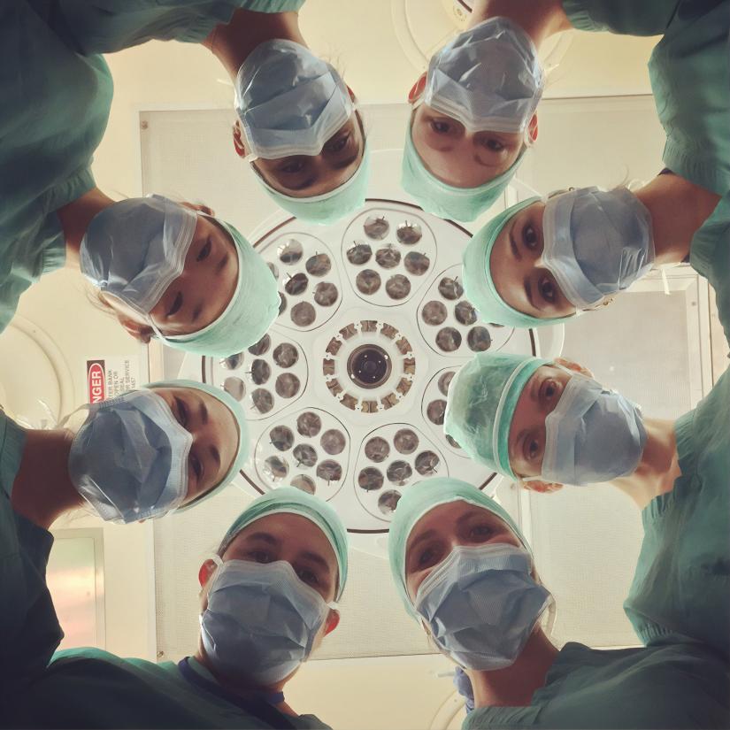 Hospital staff in circular formation look to camera