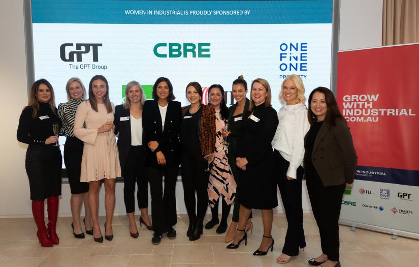 Group of women in front of a pop up banner with corporate logos