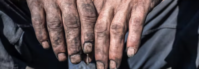 a person's fingers, dirty with coal dust