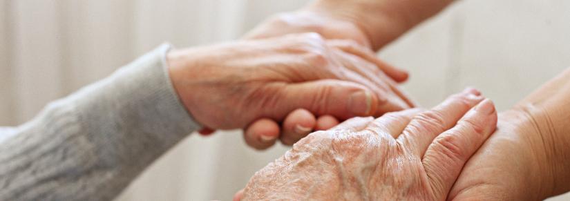 elderly hands being held by younger hands