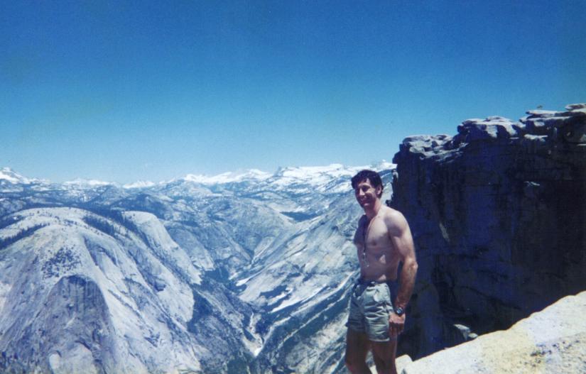 A man stands at the top of a mountain at Yosemite national park