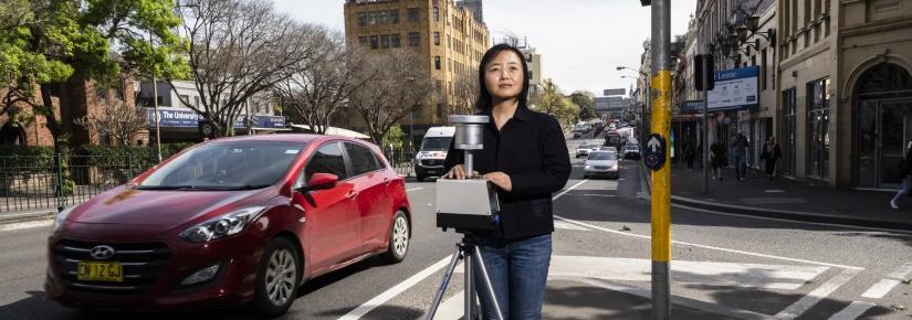 woman with air monitoring devices standing by a road