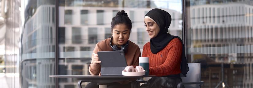 UTS Student looking at laptop on campus with headphones and reusable coffee cup
