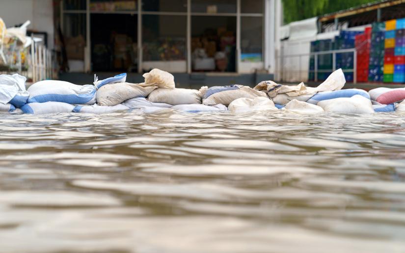 Adobe stock picture of sandbags being used to hold back floodwaters in an urban area