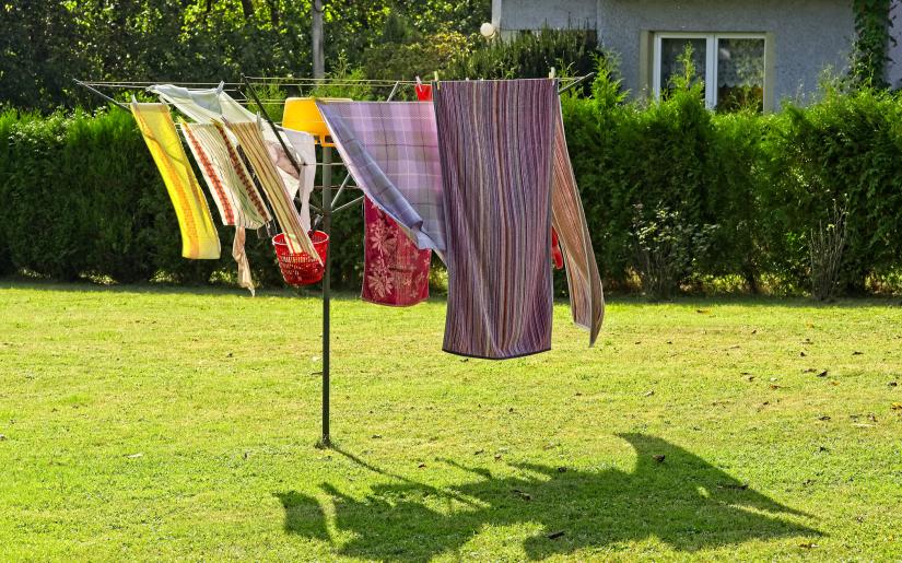 clothes swing in the breeze on a clothesline in a sunny backyard