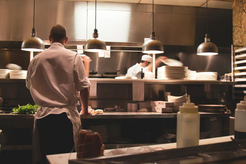 Workers prepare food in a restaraunt kitchen