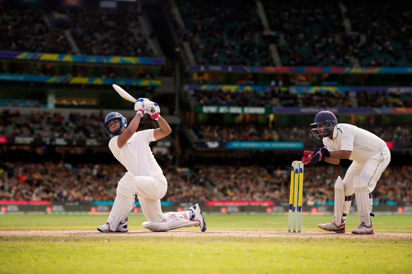 Cricketer batsman hitting a shot during a match on the cricket pitch during a match By IndiaPix