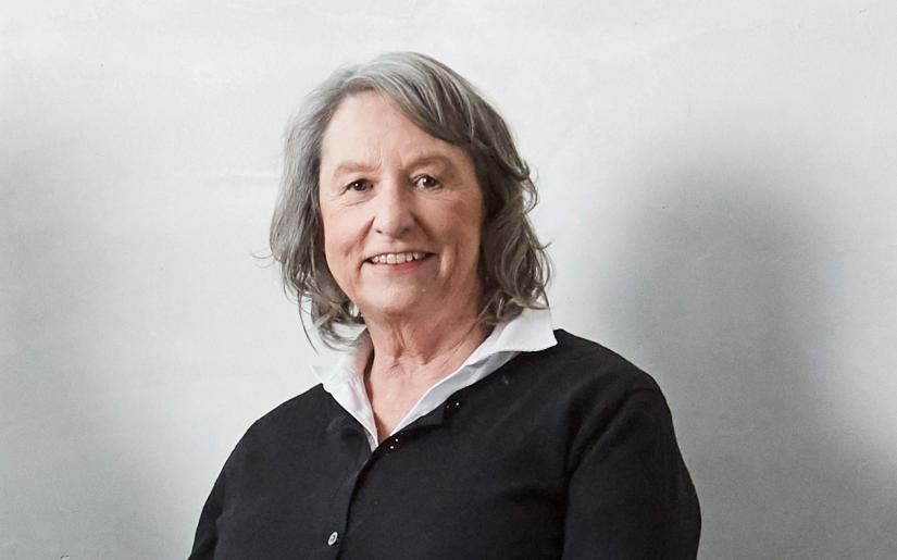 Distinguished Professor Jane Hall smiles at the camera in front of a white background.