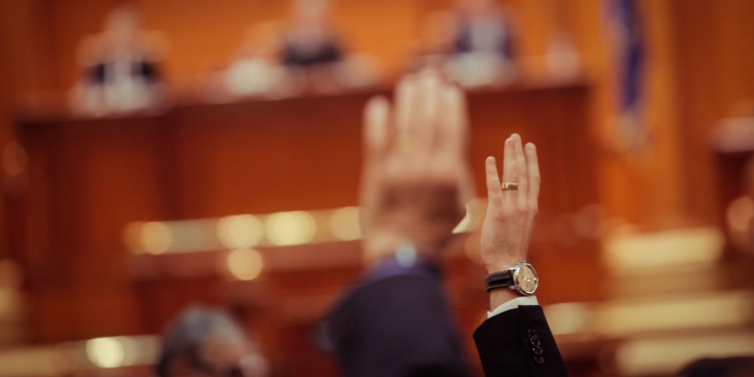 Image of two people raising their hand in the courtroom