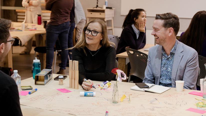 Happy people sitting at a table during a creativity exercise