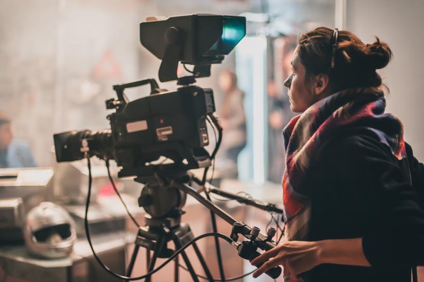 A woman controls a film camera on set