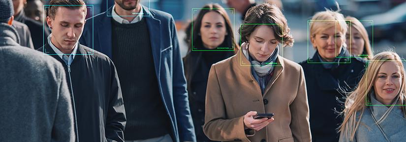 a crowd walking, facial recognition boxes superimposed on faces