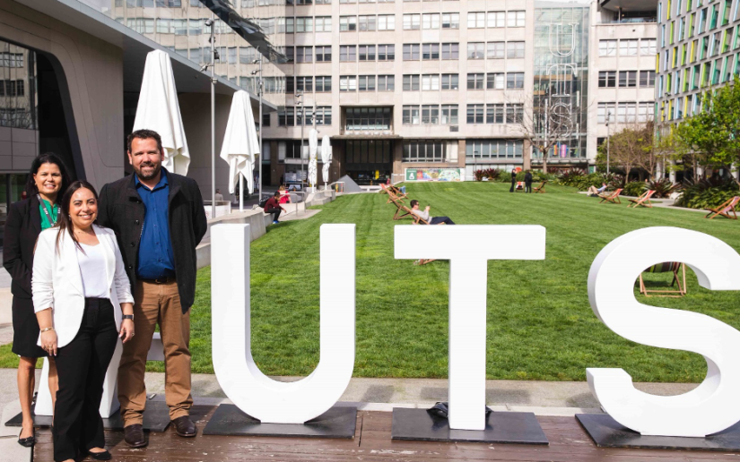 Pictured left to right: Maree Graham UTS, Cassandra Tratt Woolworths Group, Clint Johnson Woolworths Group stand next to large letters spelling UTS.