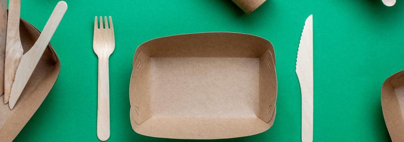 a stock photo of compostable packaging food containers, including a fork and a knife.