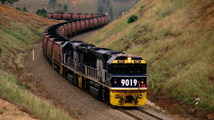 A locomotive hauls a bulk trainload of black coal