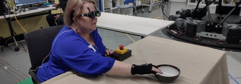 A research team member who is blind uses acoustic touch to locate and reach for an item on the table.   Image Credit: Photo taken by Lil Deverell (co-author) at the Motion Platform and Mixed Reality Lab in Techlab at the University of Technology Sydney (UTS), Australia, CC-BY 4.0