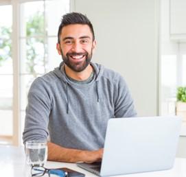 Man smiling in front of laptop