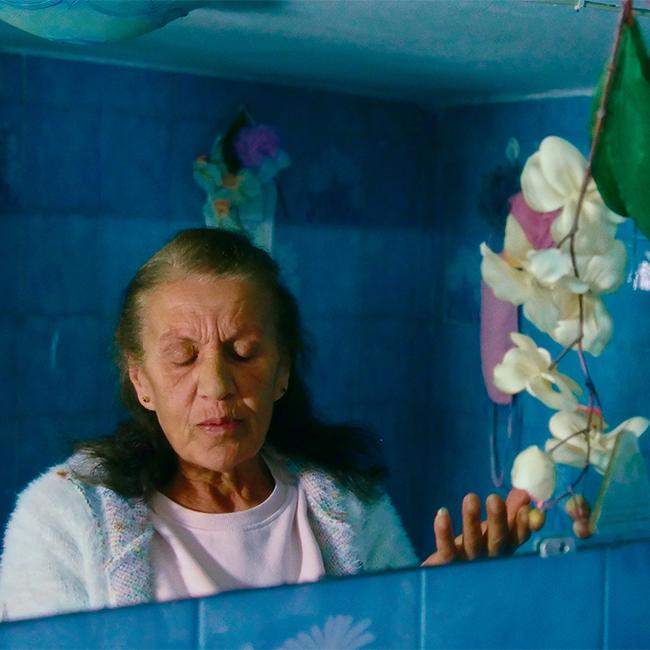 An older woman in a blue bathroom