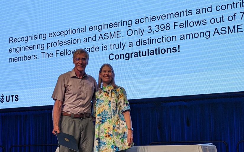 Professor Peta Wyeth stands beside Professor David Eager on stage to present the ASME Fellow Award at the FEIT End of Year Celebration Awards.