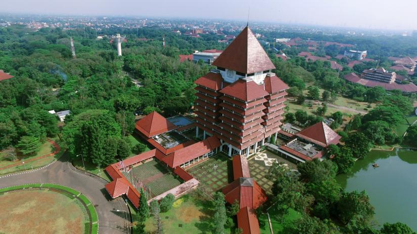 Aerial shot of Universitas Indonesia, a red brick building amongst green trees