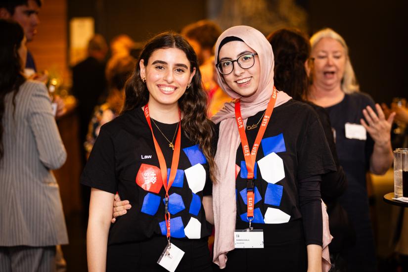 Two Brennan students in UTS law t-shirts at an event