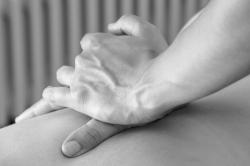 Hands massaging a person's back in osteopathic treatment