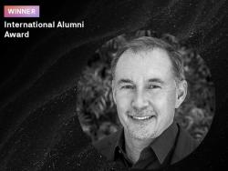 A headshot of Jim with the text 'Winner - International Alumni Award'