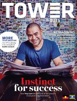 Cover page of Tower Issue 14 featuring Troy Lum smiling at the camera whilst holding an open newspaper