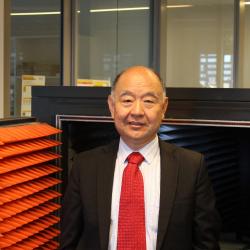 Image of Distinguished Professor Jay Guo in front of antenna mini chamber