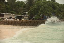 Waves crashing near coastal house in Kiribati