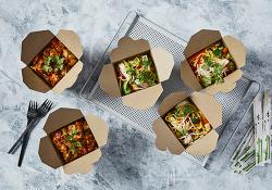 Cardboard takeaway boxes filled with noodles and colourful vegetables