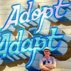 Brent Jacobs in front of wall reading "Adopt and adapt"