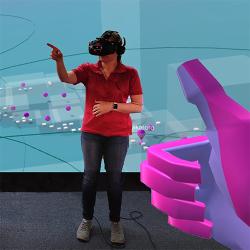 Person in VR headset pointing, large pink digitised thumbs up in the foreground. 