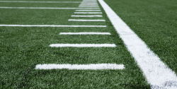 Close up shot of a sports field with white grid iron lines painted
