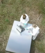Aerial view of forensic scientists working on a steel table outdoors