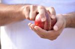 Cricket bowler hands holding ball