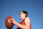 Young AFL player holding ball