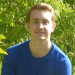 QSI's Ryan Mann profile picture with greenery in the background. Ryan is wearing a royal blue t-shirt