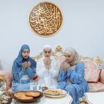 Three women pray before breaking their fast for Ramadan