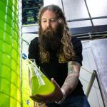 bearded man filling up algae beer